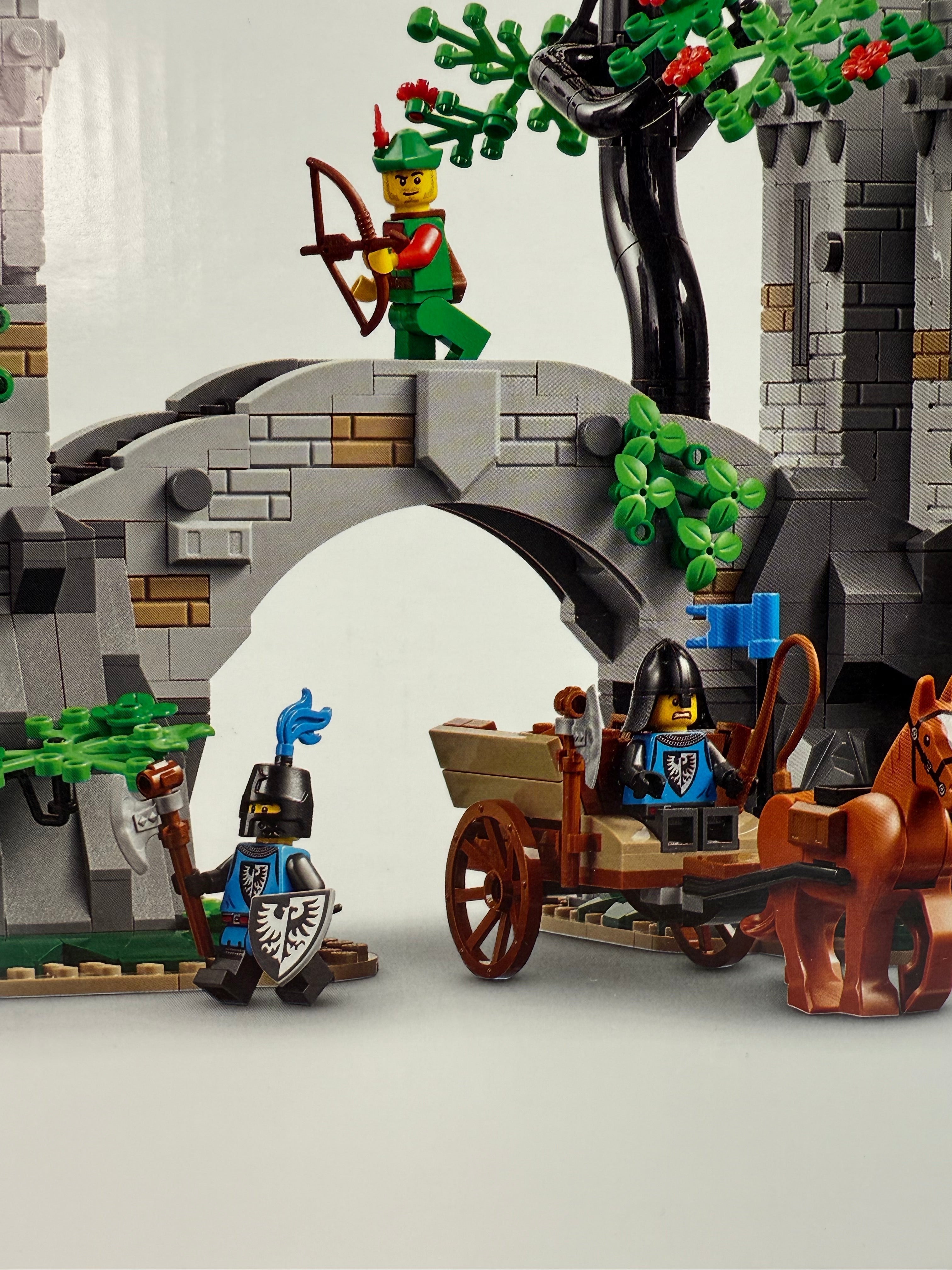 Legacy Brick LEGO Forest Stronghold set 910043 featuring medieval castle ruins, minifigures, and horse-drawn cart.